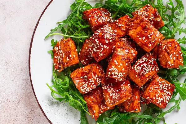 Kızarmış somon dilimleri, susamlı teriyaki roka salatası, en iyi manzara.,