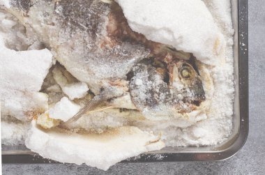 Fırınlanmış Dorado balığı, bir tepside tuz, üst manzara, ev yapımı, insan yok..