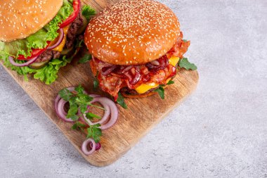 İki köfteli burger, kızarmış pastırma, çedar peyniri, domates, ev yapımı, insan yok.,