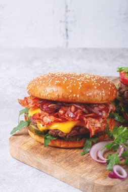 Biftek ve pastırmalı hamburger, roka ve karamelli soğan, turşu, sos, ev yapımı, insan yok.,