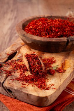 Baharat safranı iplikleri, ahşap bir kasede, ahşap bir masanın üstünde, üst manzara, yakın çekim.,