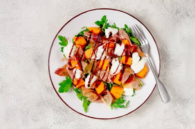 Olgun kavun dilimli salata, prosciutto, mozzarella ve balzamik jöleli taze roka..