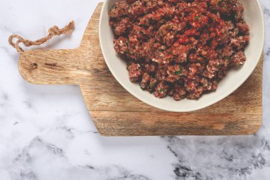 Çiğ kıyma, baharat ve otlarla marine edilmiş, bir kasede, baharatlı kıyma, üst manzara, ev yapımı, insan yok.,