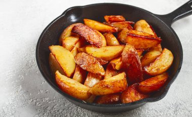 Kızarmış patates dilimleri, dökme demir bir tavada, ev yapımı, insan yok.,