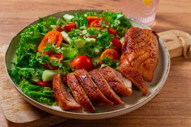 Lezzetli ızgara ördek göğsü taze bahçe salatası ve kiraz domatesleriyle servis edilir.