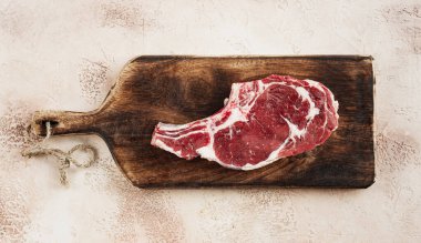 Çiğ biftek, kovboy bifteği, tahta doğrama tahtası, mermer masa, üst manzara, insan yok.,