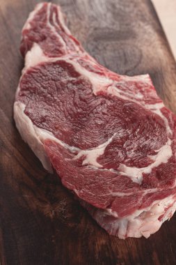 Çiğ biftek, kovboy bifteği, tahta doğrama tahtası, mermer masa, üst manzara, insan yok.,