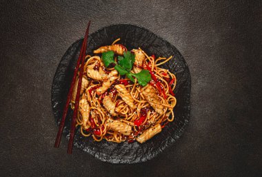 Udon eriştesi, kalamar ve sebzeli, siyah tabakta, ev yapımı, insan yok.,