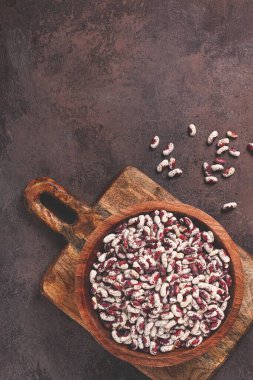 Değişik fasulyeler, beyaz benekli kırmızı, ahşap kasede çiğ, üst manzara, insan yok.,