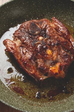 Kızarmış biftek, kemikte dana boynu, kızartma tavasında et pişirme, üst manzara, insan yok.,