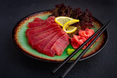 Taze ton balığı sashimi, limon, wasabi ve zencefil turşusu ile servis edilir.