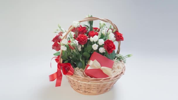 一束带着礼物在篮子里的花在白色的背景上旋转 — 图库视频影像