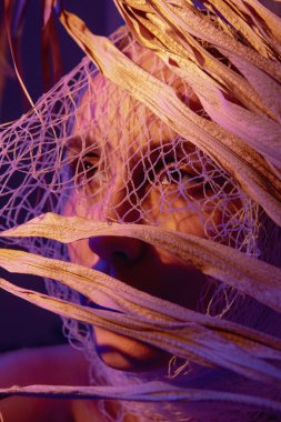 Kırmızı ışığa sarılmış bir kız yüzünü saklar.