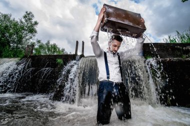 Sakallı adam bavulunu suya koydu.