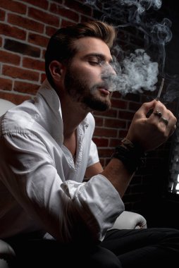 Tarz sahibi bir Arap otururken iş görüşmesi yapıyor.