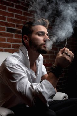 Tarz sahibi bir Arap otururken iş görüşmesi yapıyor.