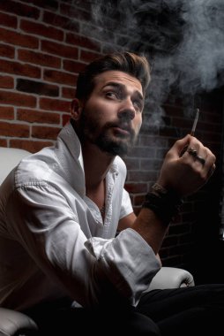 Tarz sahibi bir Arap otururken iş görüşmesi yapıyor.