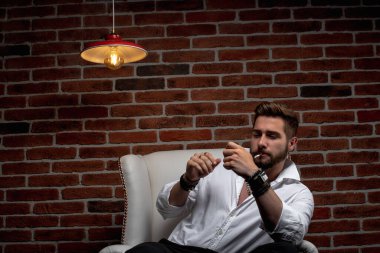 Tarz sahibi bir Arap otururken iş görüşmesi yapıyor.