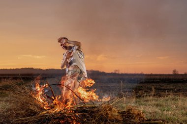 Yanmış kıyafetlerle ağlayan genç adam Tanrı 'dan yardım, savaş, ev yıkım, insani hayal kırıklığı diliyor.