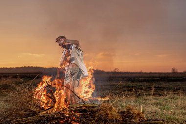 Yanmış kıyafetlerle ağlayan genç adam Tanrı 'dan yardım, savaş, ev yıkım, insani hayal kırıklığı diliyor.