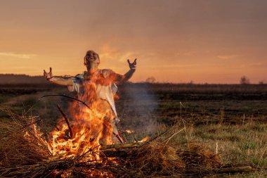 Yanmış kıyafetlerle ağlayan genç adam Tanrı 'dan yardım, savaş, ev yıkım, insani hayal kırıklığı diliyor.
