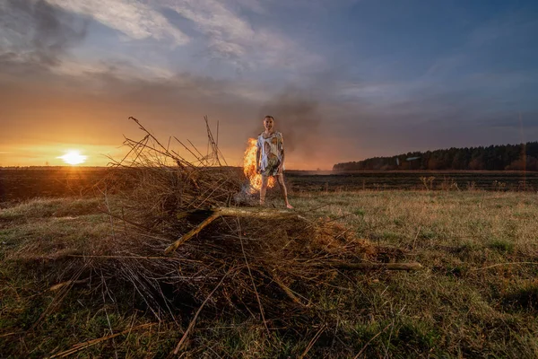 stock image young guy crying in fire in burnt clothes asking God for help, war, house destruction, human disappointment