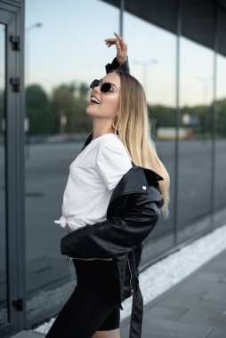 Deri ceketli ve alışveriş merkezinin yanında siyah gözlüklü güzel bir kız.