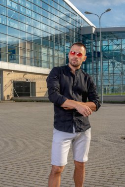 Siyah tişörtlü ve şortlu güzel vücutlu genç bir adam. 