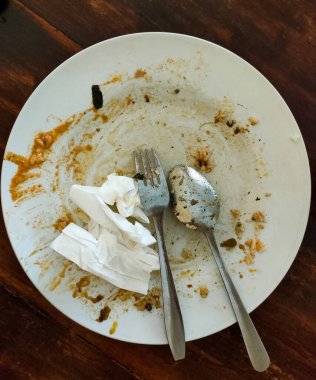 Kirli tabaklar hala yiyecek kalıntıları bırakıyor.