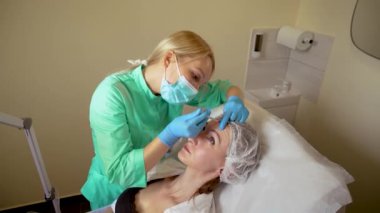 Kozmetik uzmanı kadın derisine hiyalüronik asit enjekte ediyor. Profesyonel kozmetik uzmanı cilt yenilenmesi için nörotoksin enjekte ediyor.