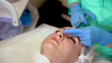 Kozmetik uzmanı kadın derisine hiyalüronik asit enjekte ederek birçok enjeksiyon yapıyor. Modern insanlar için profesyonel nemlendirici ve gençleştirici tıbbi prosedürler