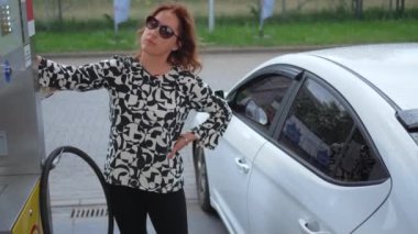 Benzin deposunda benzin dolduran kadın. Benzin istasyonunda kadın yakıt ikmali.