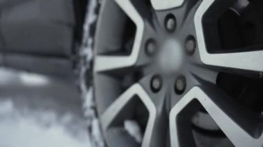 Gri araba büyük tekerler yavaş yavaş dönüyor ve ıslak karı tükürüyor. Bilinmeyen sürücü, kışın derin kar yığınlarıyla karlı yoldan geçmeyi deniyor. SUV aracı yol tutuşu kazanmaya çalışıyor