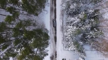 Karlı buz yolunda giden arazi aracının kışın yerel manzaraları keşfettiği hava görüntüsü. Seyahat yolculuğu ve sağlıklı aktif yaşam tarzı konsepti