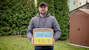 Sorumluluk sahibi kadın portresi, içinde bağışlanmış yiyecek ve ilgili insanlardan gelen Ukraynalı mülteciler için insani yardım bulunan karton bir kutu tutuyor. Rus saldırısıyla savaşta Ukrayna 'ya yardım et.