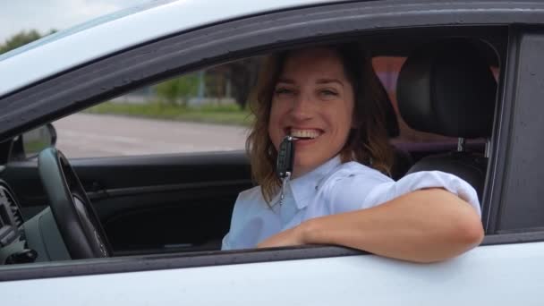 Щасливий Власник Автомобіля Тримає Ключі Зубах Весела Молода Жінка Сидить — стокове відео
