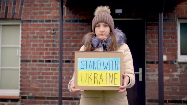 持硬纸板 向乌克兰难民提供粮食和人道主义援助的妇女志愿者 以支助中心为背景 帮助乌克兰与俄国的侵略作战 — 图库视频影像