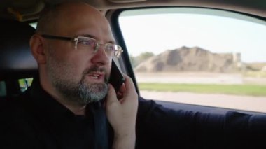 Kızgın sürücü, araba sürme tehlikesi ve hayat sigortası varken cep telefonuyla konuşurken duygusal ve stresli bir şekilde konuşuyor. Kırsal kesimde otobanda seyahat eden, SUV 'de yakışıklı bir adam.