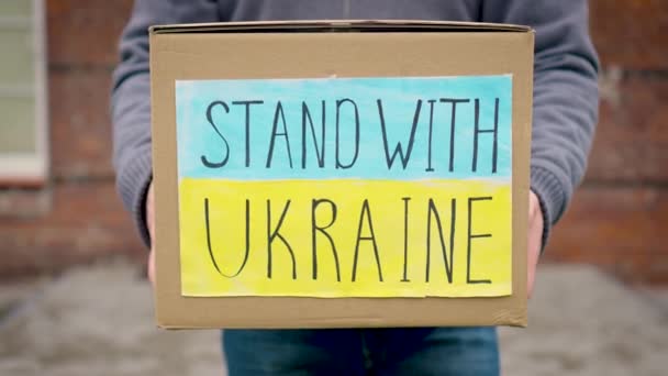 ボランティア女性の手でウクライナ難民のための食糧と人道援助のボール紙を閉じます ロシア侵略との戦争でウクライナを助ける — ストック動画
