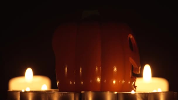Oświetlająca Dynia Halloween Obracająca Się Ciemnym Tle Płonącymi Świecami Woskowymi — Wideo stockowe