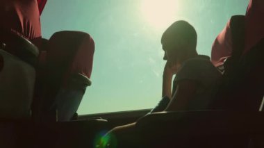 Otobüsün içindeki yolda giden düşünceli bir çocuk. Hayalperest ergen çocuk, trende kulaklıkla müzik dinliyor. Genç adam savaş yüzünden evden ayrıldığı için acı ve umutsuzluk hissediyor.