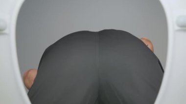 Adam kullanılmış tuvalet kağıdını kaseye atıyor. Kel sakallı erkek dışkıladıktan sonra tuvalete bakıyor. Tuvaletin dibinden bak. Temizlik ve hijyen kavramı