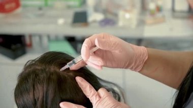Saç enjeksiyonu. Güzellik uzmanı saç büyütmek için kafa derisine iğne yapıyor. Saç uzatmak ve güzellik salonunda güçlenmek için mezoterapi. Saç dökülmesine karşı prosedür. Artırılmış cilt prosedürü ve güzellik