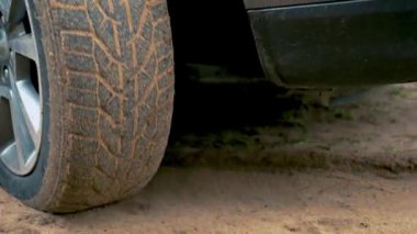 Hareket başladığında arabanın tekeri kumlu toprak yolda kaymış. Kirli yolda dönen lastik. Otomobil off-road