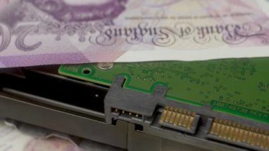 Banknotlar İngiliz sterlini, dolar, avro, yakın plan. Bankacılık bilgilerini içeren bilgisayar diski HDD. Para birimiyle oynuyoruz. İş, finans, enflasyon ve deflasyon kavramı