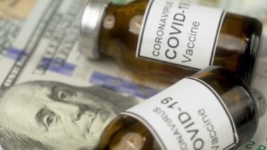 Amerikan parası tıbbi aşılara yatırıldı. Makro cam şişeyi ve dolarları kapatır hastane eczacılık sektöründe pahalı ilaçlar. Sağlık ve tıbbi kavramlar. Para ve ilaç.