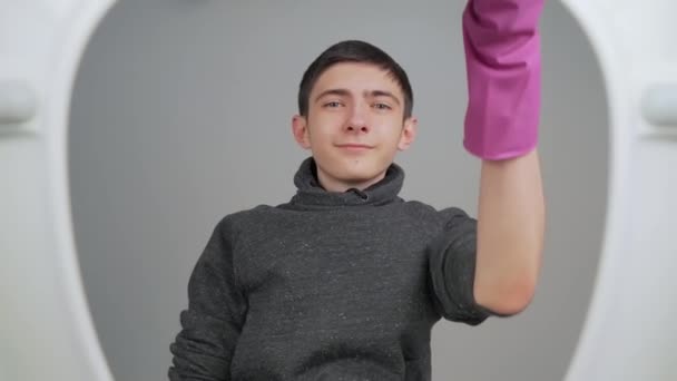 Jonge Tiener Draagt Paarse Handschoenen Met Plunjer Voor Het Toilet — Stockvideo