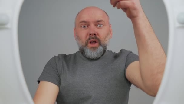 Homem Careca Com Mãos Levantadas Frente Banheiro Expressando Frustração Confusão — Vídeo de Stock
