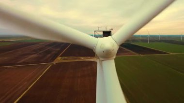 Rüzgar türbinleri enerji üretiyorlar. Bulutlu bir günde tarlada bıçaklı yel değirmenleri. Elektrik tasarrufu kavramı ve alternatif güç kaynağı, ekolojik koruma