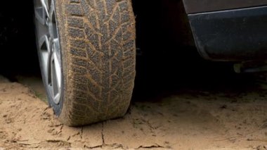 Araç ESP sistemi kumlu arazide gezinen bir araç olarak çalıştırıldı. Aracın dönen çarkı kapanıyor. Kirli yolda dönen lastik. Otomobil off-road